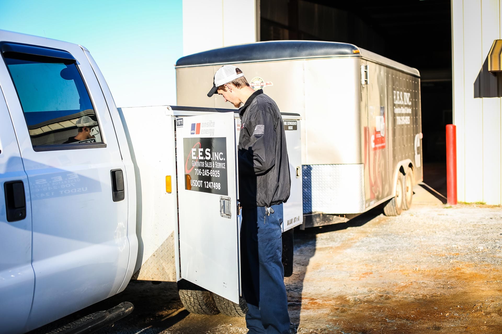 E.E.S. Inc. | employee outside beside a company truck and trailer